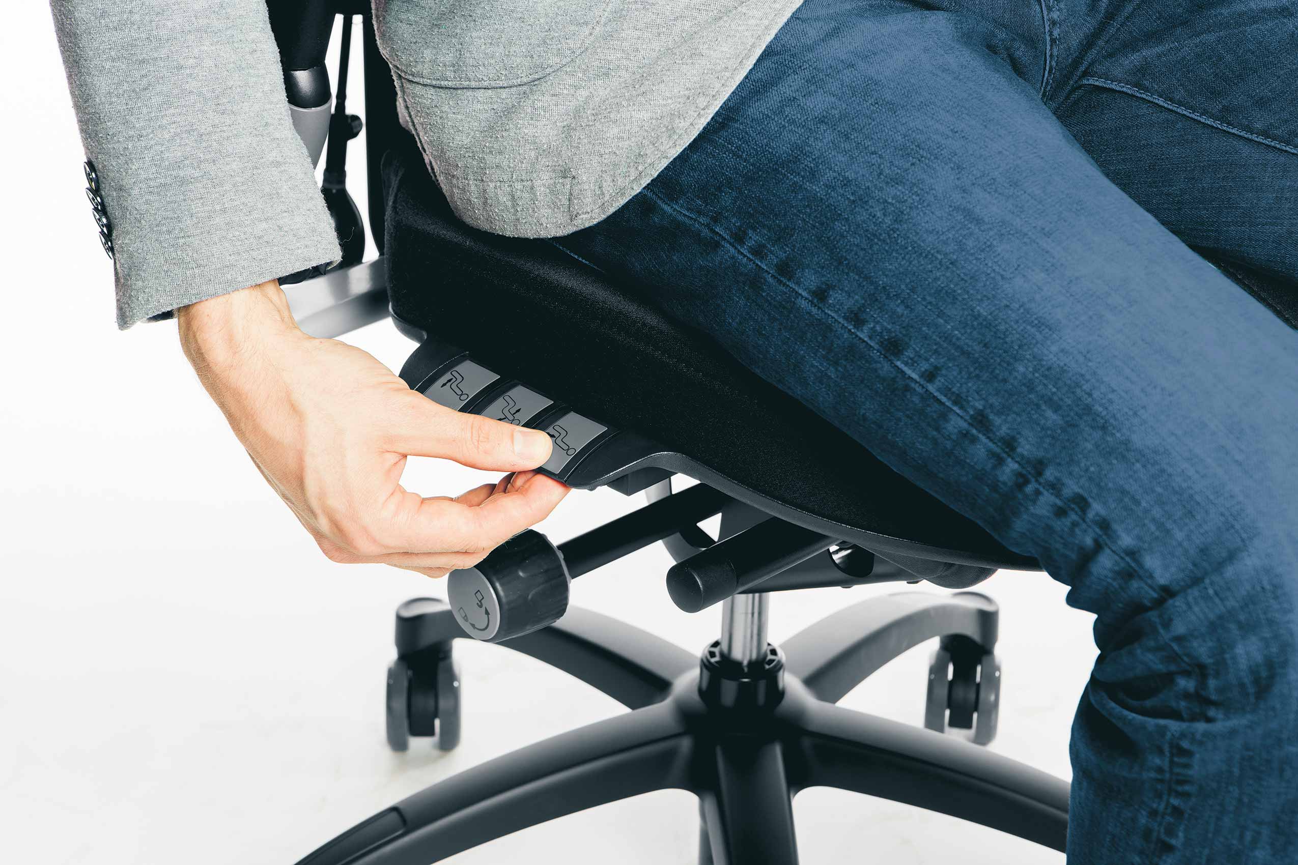 Close up of man using adjustments on RH Logic ergonomic chair