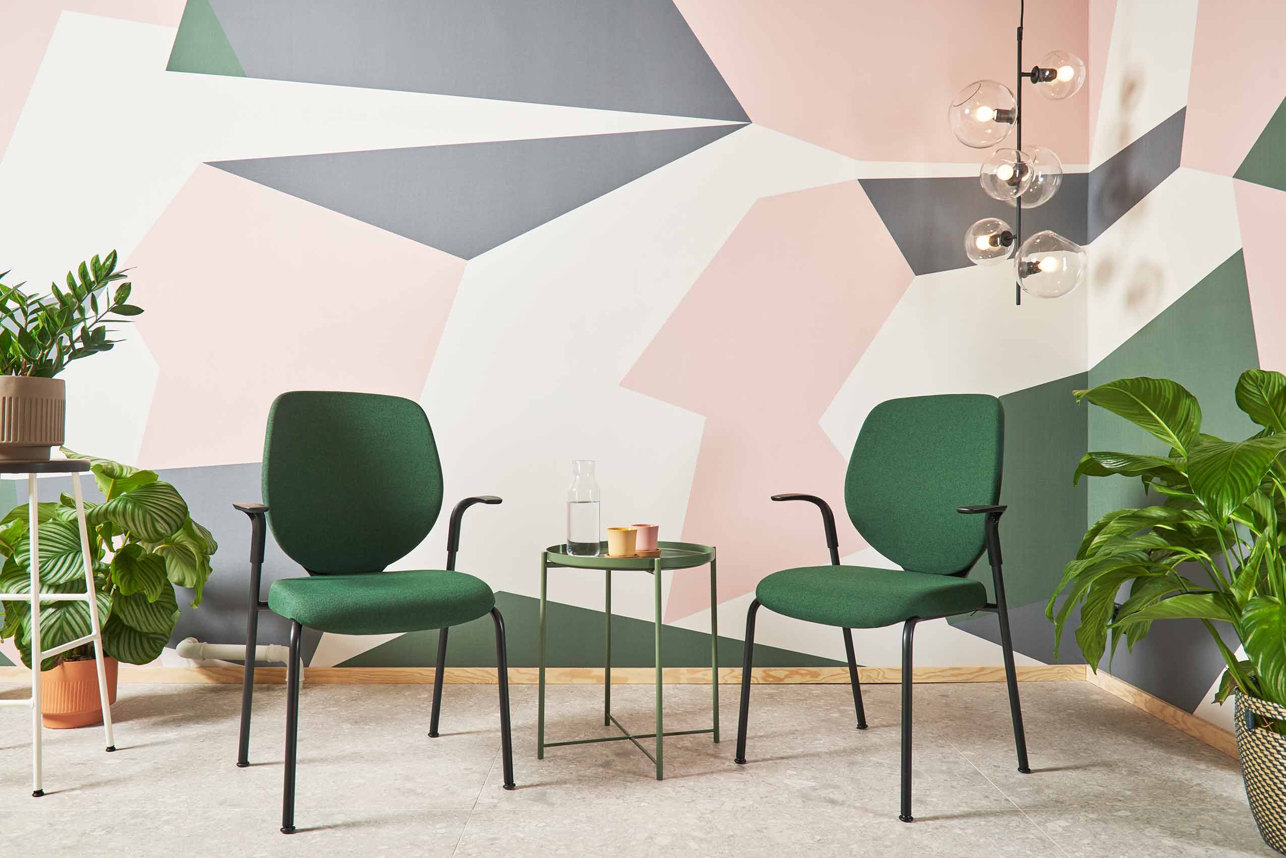 two green giroflex 353 chairs in a social area at Cospire co-work lausanne, with pink grey and white wall paint