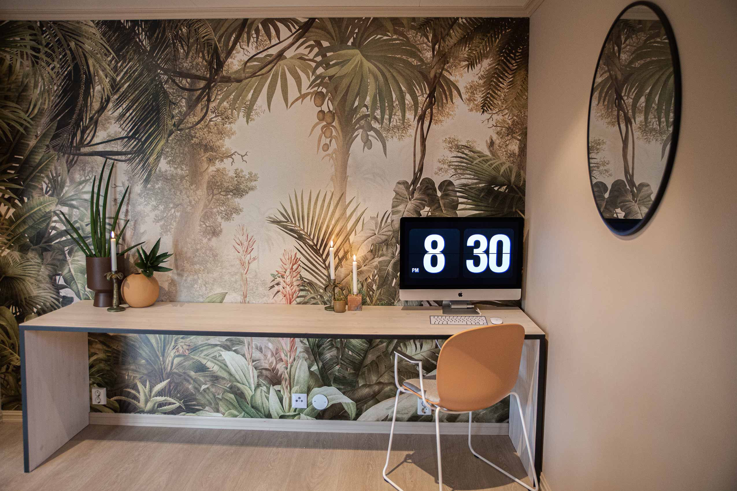 Coral RBM Noor chair at a side table with a palm treee mural wall covering and a clock showing 8:30