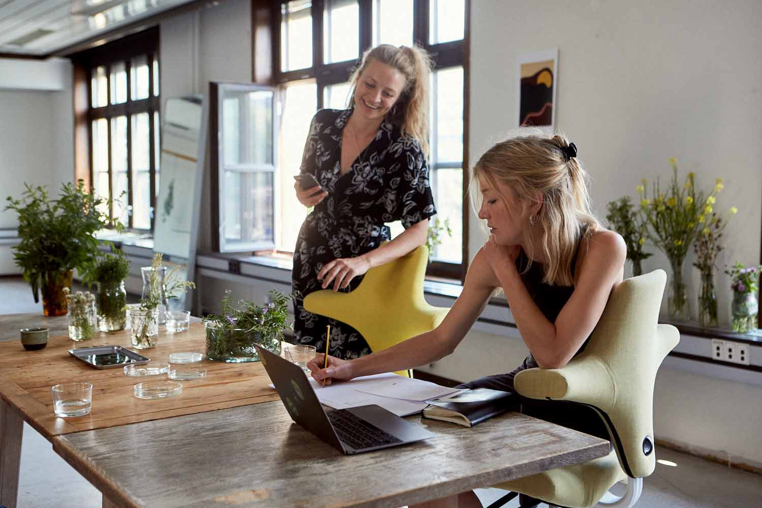 two ladies doing deskwork whilst sat on HÅG Capisco chairs