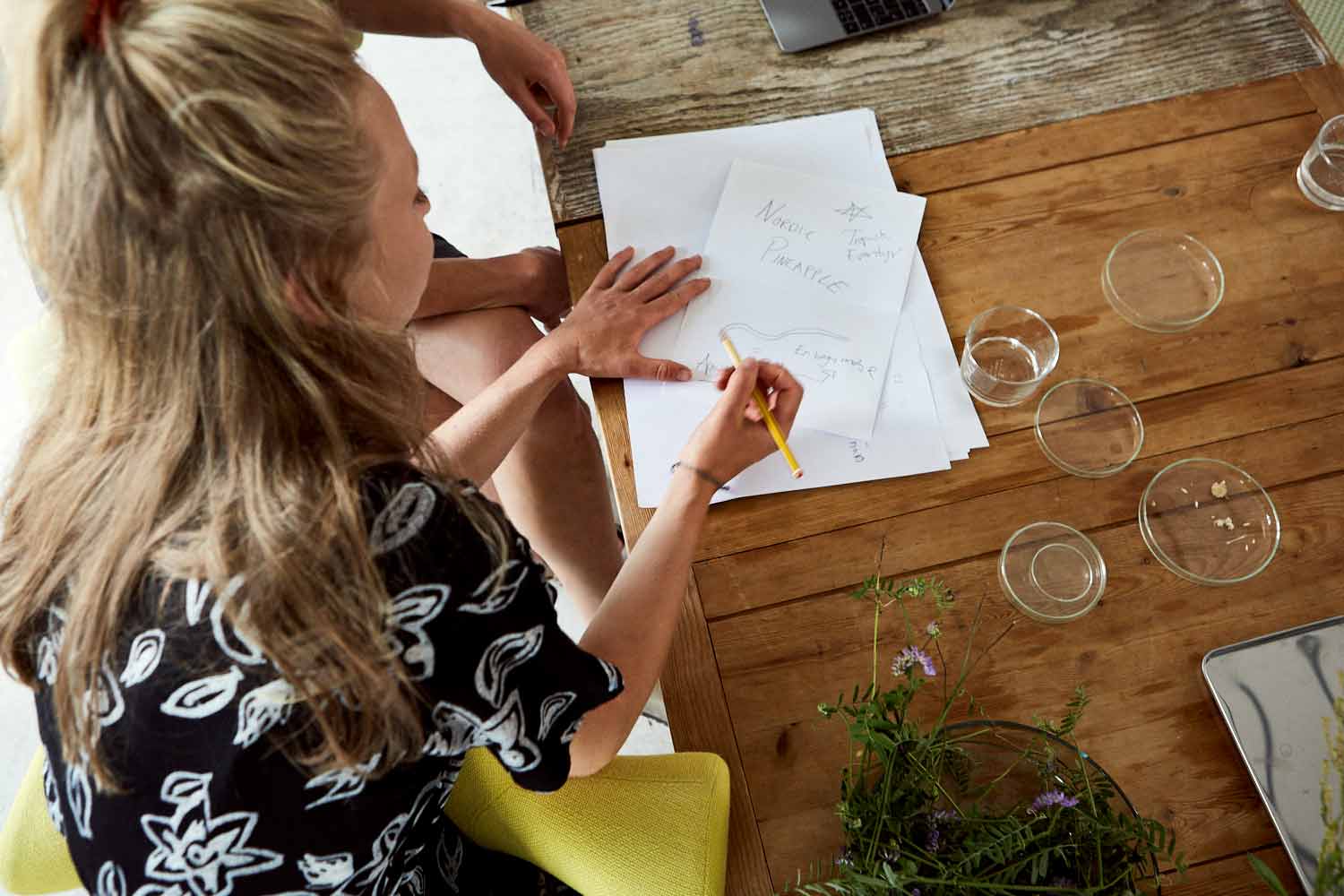 lady drawing artwork sat on yellow hag capisco chair