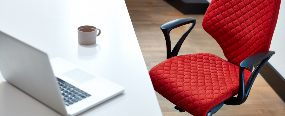 Red quilt fabric on giroflex 64 chair at a desk with a laptop